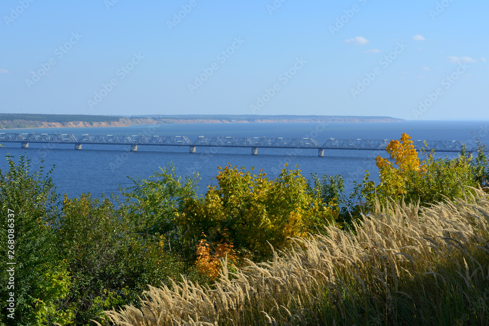 The bridge over the Volga river in sunny september day. View from top with trees and cereals on the foreground.
