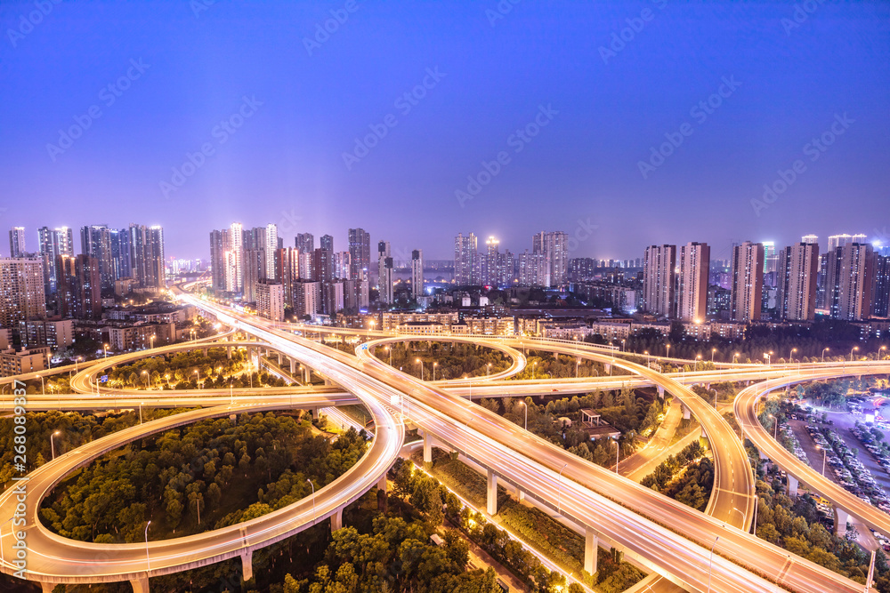Fototapeta premium urban overpass at dusk, modern city skyline and traffic background.Wuhan, the largest transportation and economic hub city in central China.
