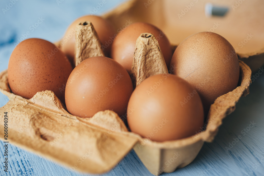 Eggs background. Closeup view of eggs in carton box on wooden table. Eggs background. Closeup view of eggs in carton box on wooden table.