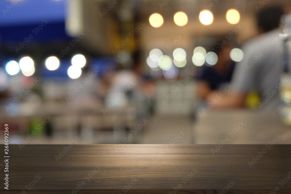 Empty dark wooden table in front of abstract blurred bokeh background of restaurant . can be used for display or montage your products.Mock up for space.