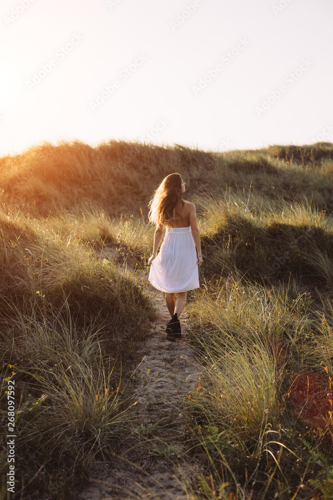 Natural woman walking outdoor at sunset Natural woman walking outdoor at sunset