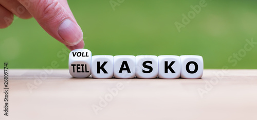 Hand dreht einen Würfel und ändert das Wort "Teilkasko" in "Vollkasko" (oder umgekehrt).