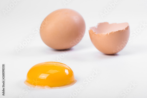 Broken egg isolated on white background. Raw egg yolk