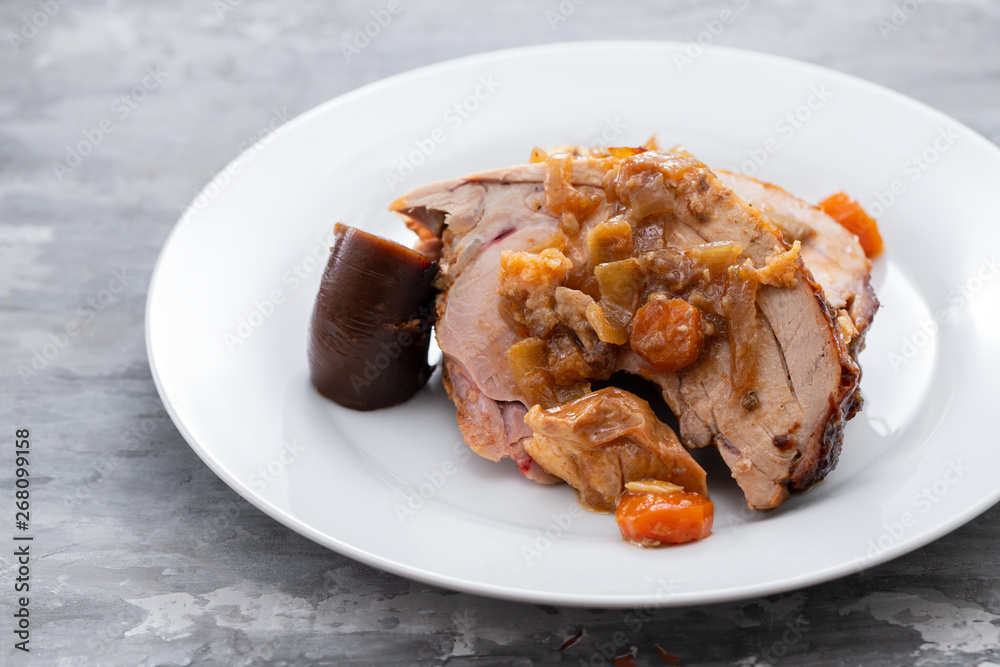 baked turkey leg with vegetables, smoked sausage and herbs on white dish baked turkey leg with vegetables, smoked sausage and herbs on white dish