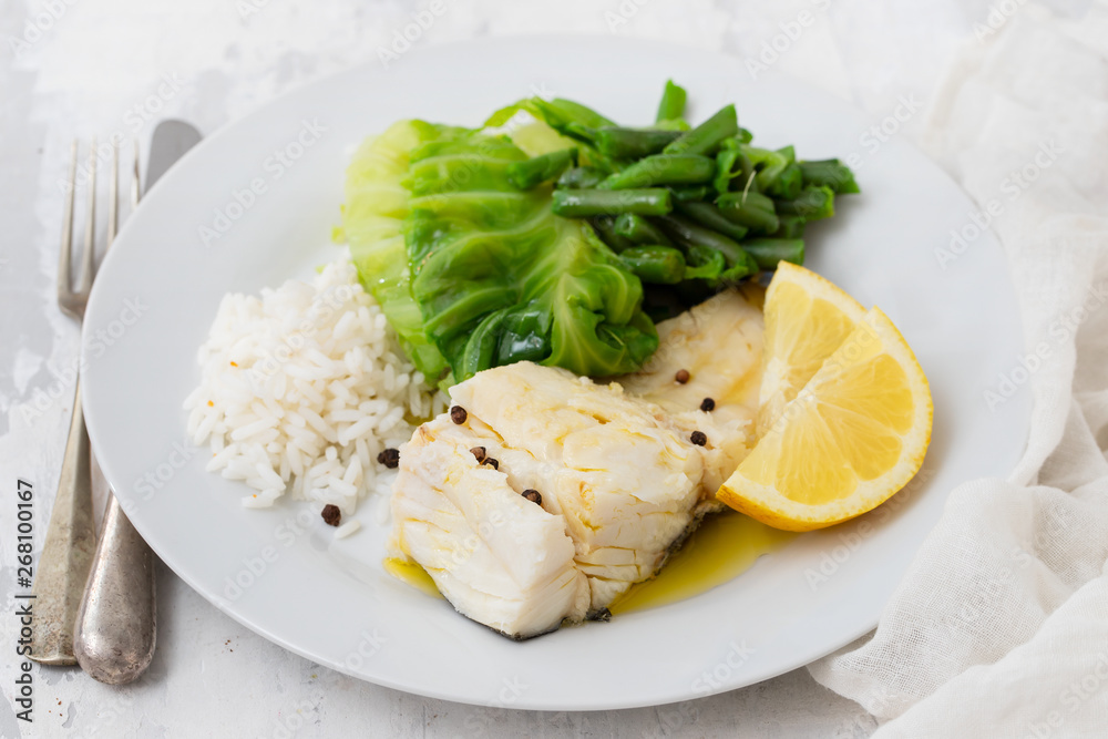 boiled cod fish with rice and vegetables on white plate boiled cod fish with rice and vegetables on white plate