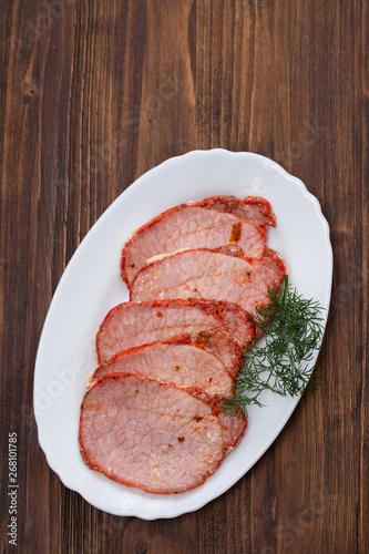 fried pork with herbs on white dish on wooden background
