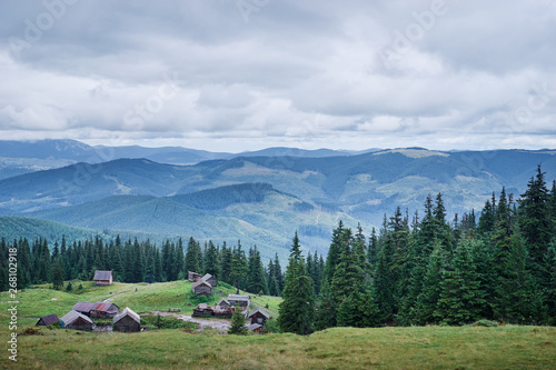 Beautiful mountains landscape with green meadow and village. Carpathians, Ukraine.