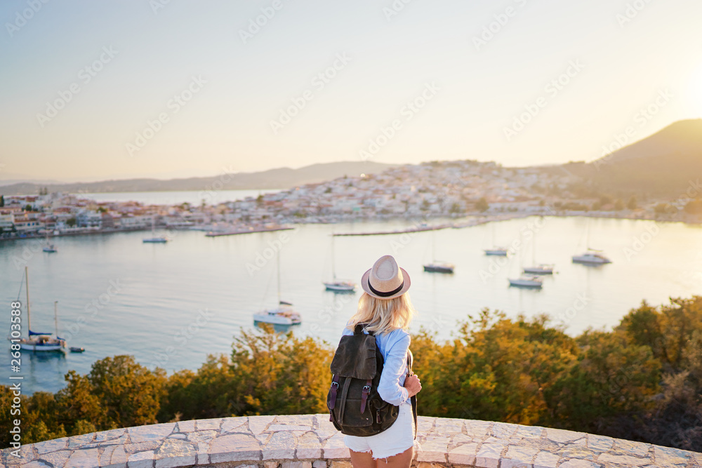 Fototapeta premium Enjoying vacation in Greece. Young traveling woman enjoying sunset on sea view point.
