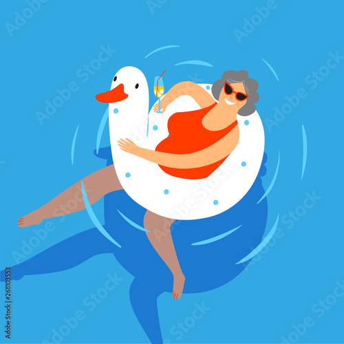 Old lady swimming in a pool with a cocktail.