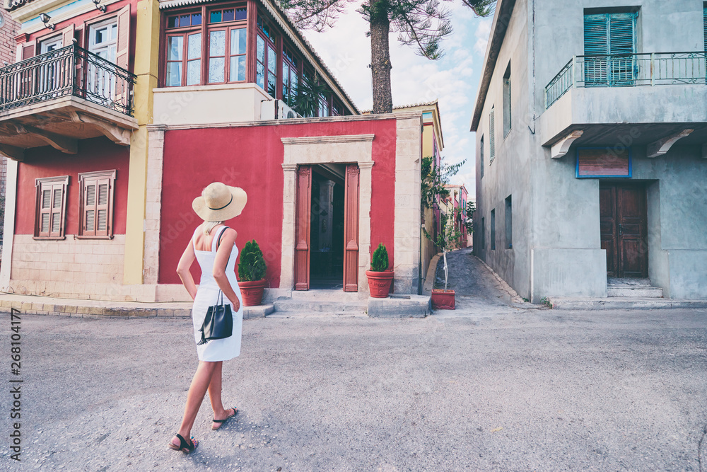 Young traveling woman in hat walking on old town enjoying the view.