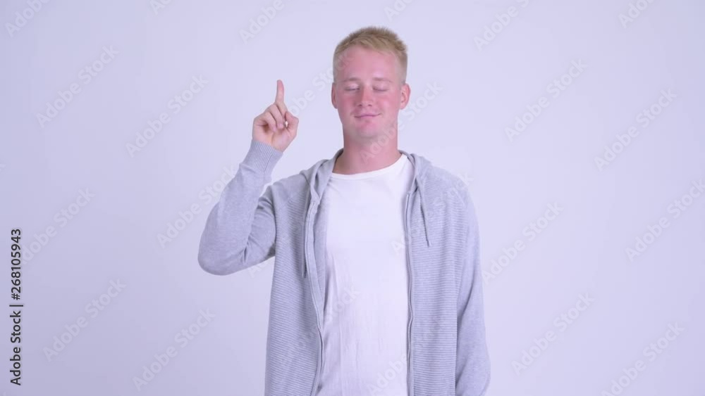 Happy young blonde handsome man talking while pointing up Happy young blonde handsome man talking while pointing up