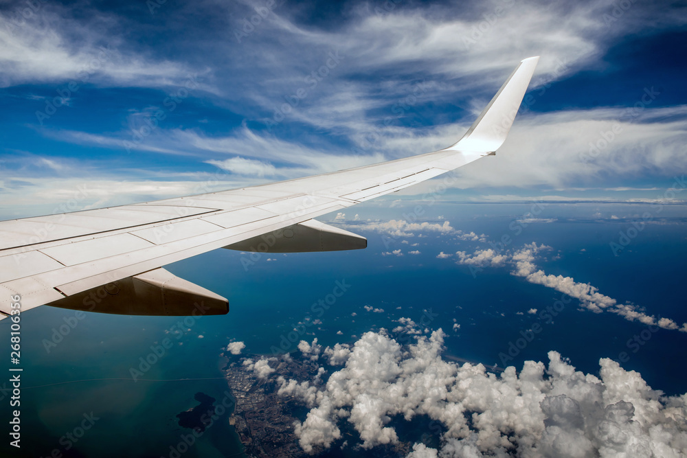 Fototapeta premium Wing of airplane in cloudy sky