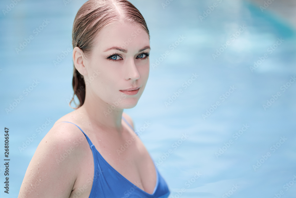 Enjoying vacation. Sensual portrait of  beautiful young woman in swimming pool.