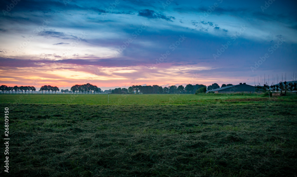 Colorful sunrise, typical Dutch agricultural landscape