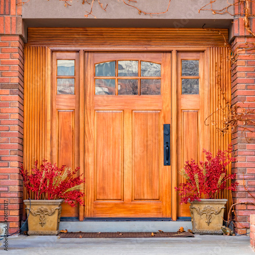 Clear Square Brown wooden front door with decorative glass panels at the entrance of a home