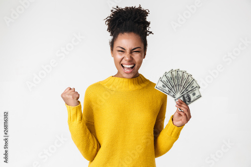 African excited emotional happy woman posing isolated over white wall background holding money.