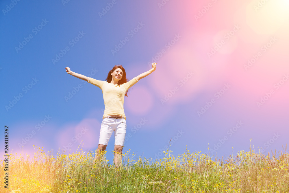 People freedom success concept. Happy woman dreams to fly on winds. Landscape of grass and flower summer field on sunny day. Nature beauty background, blue sky and green meadow. Outdoor lifestyle. People freedom success concept. Happy woman dreams to fly on winds. Landscape of grass and flower summer field on sunny day. Nature beauty background, blue sky and green meadow. Outdoor lifestyle.