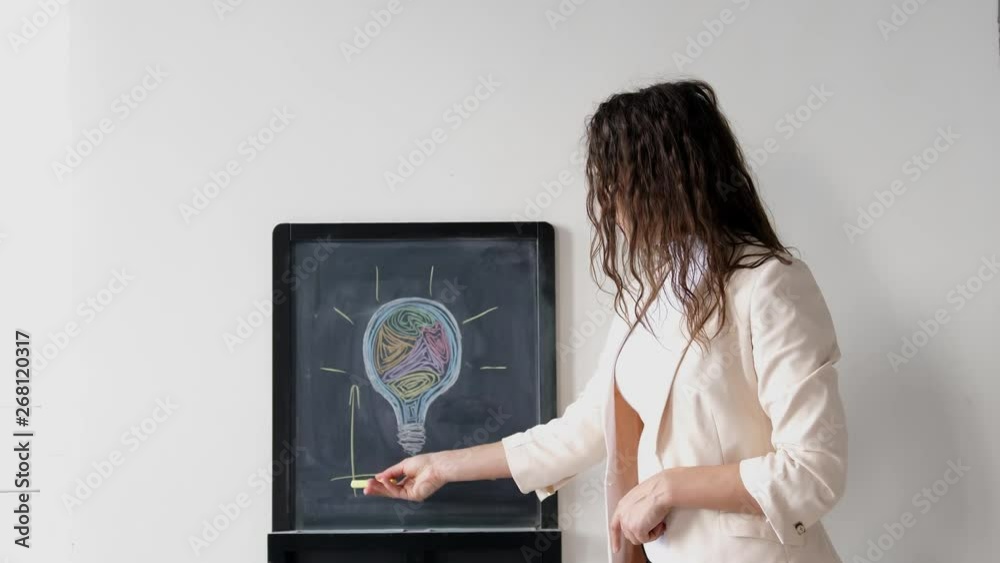 Creative young businesswoman in suit draws charts on board . 3840x2160 Creative young businesswoman in suit draws charts on board . 3840x2160