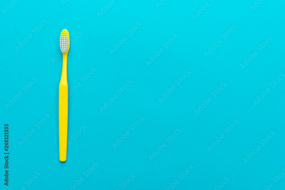 top view of plastic toothbrush on the blue background. minimalist flat lay photo of yellow toothbrush over turquoise blue background with copy space top view of plastic toothbrush on the blue background. minimalist flat lay photo of yellow toothbrush over turquoise blue background with copy space