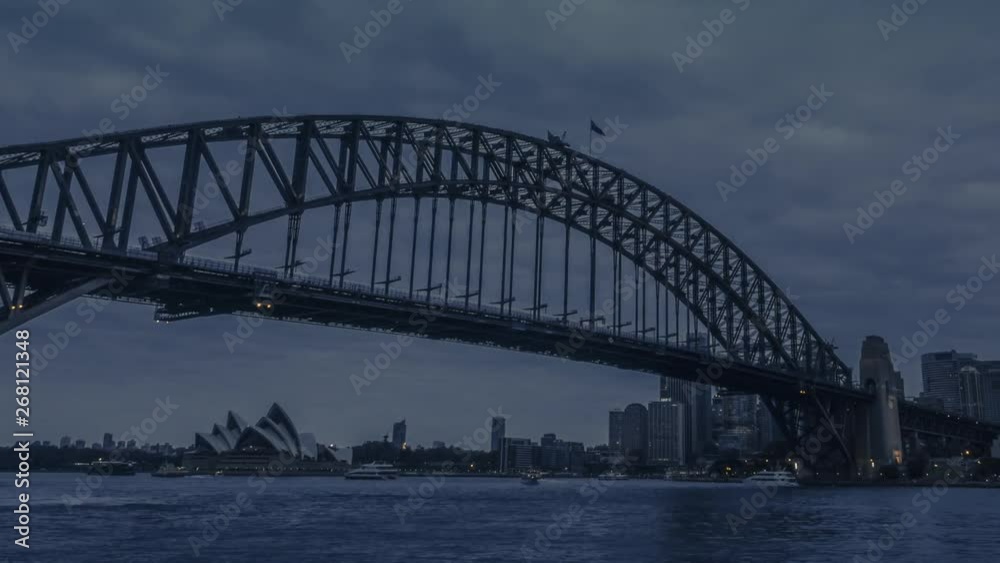 Day to night timelapse of Sydney Harbour Bridge with the cityscape of Sydney skyscrapers and office buildings in the evening from daylight until complete darkness. Day to night timelapse of Sydney Harbour Bridge with the cityscape of Sydney skyscrapers and office buildings in the evening from daylight until complete darkness.