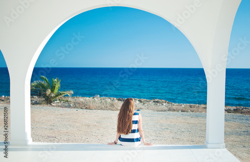 Image of a back of one caucassian girl in striped dress with long brown hair