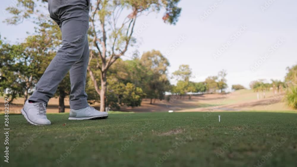 Golfer hitting the ball with a driver down the course Golfer hitting the ball with a driver down the course