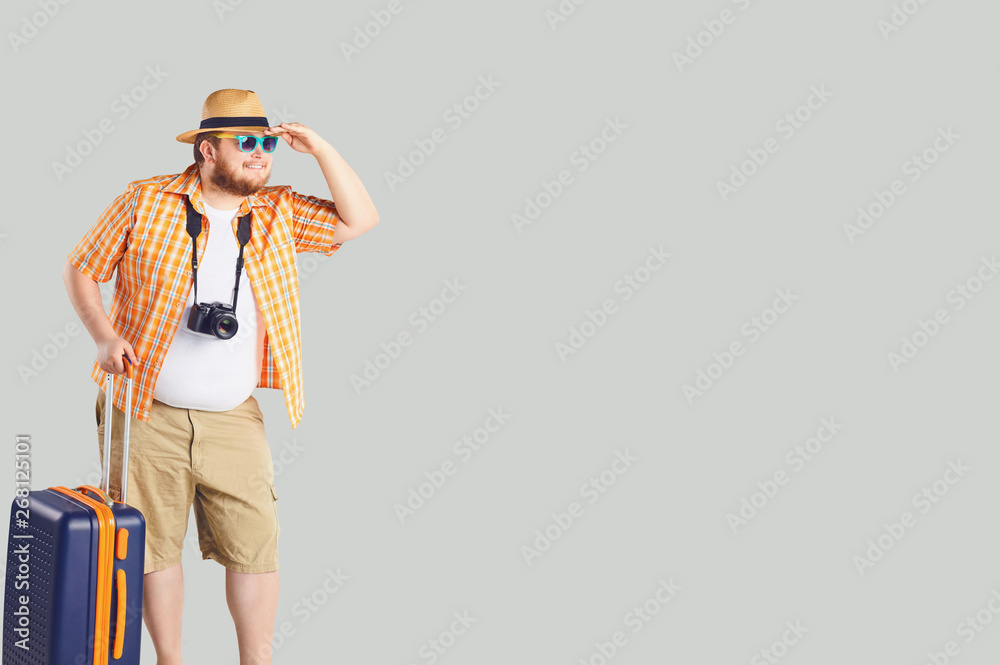 Funny fat man with a suitcase looking to travel in gray background. Funny fat man with a suitcase looking to travel in gray background.