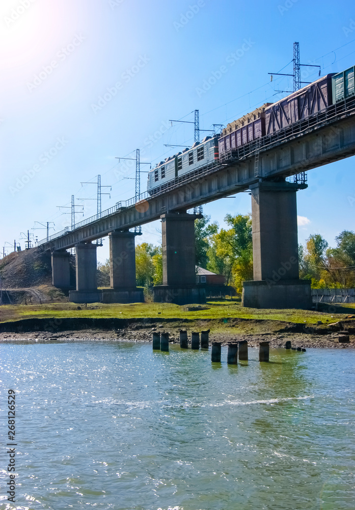 The bridge across the river. Train passing by the bridge over the river The bridge across the river. Train passing by the bridge over the river