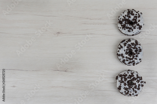 Donuts on a white wood background. Top view, copy space