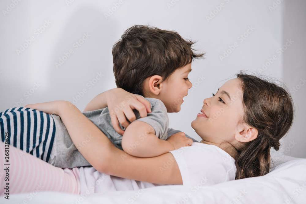 cheerful kid hugging happy toddler brother in bedroom cheerful kid hugging happy toddler brother in bedroom