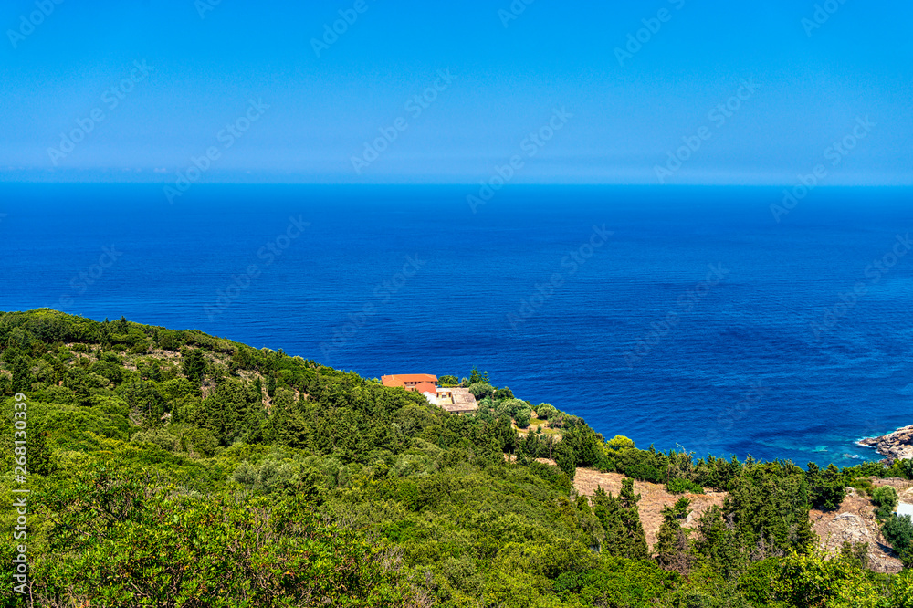 green mediterranean hill next to the blue sea