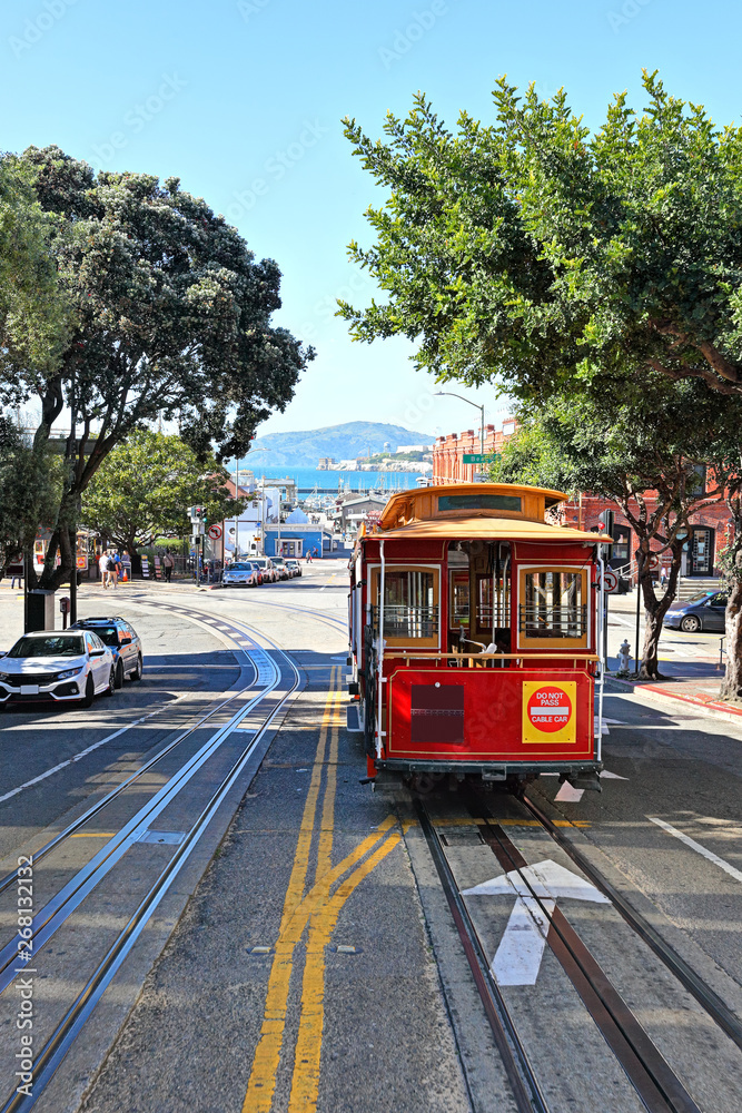 The streets of San Francisco: The iconic cable car travelling up Hyde Street with Alcatraz in the background