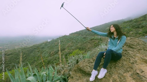 young traveler girl making photos with fascinating view of volcanic rocks