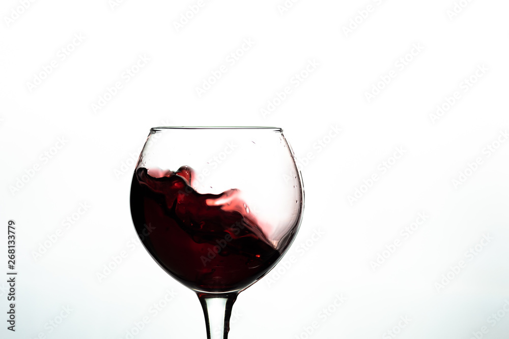 Red wine splash into glass on white background Red wine splash into glass on white background