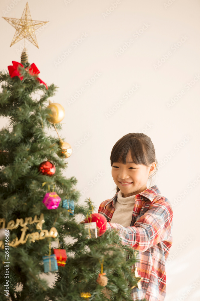 クリスマスツリーの飾り付けをする女の子 クリスマスツリーの飾り付けをする女の子