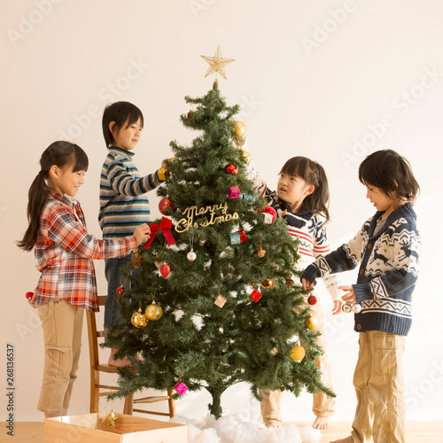 クリスマスツリーの飾り付けをする子供達