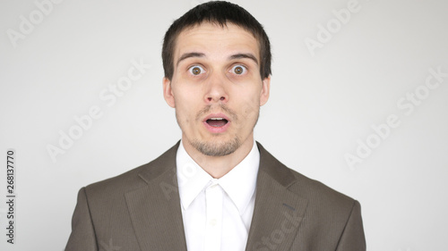 Close-up face of a young emotional man with brown eyes.