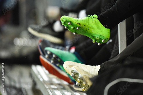 Fotografi Professional football studded boots of players sitting on the bench