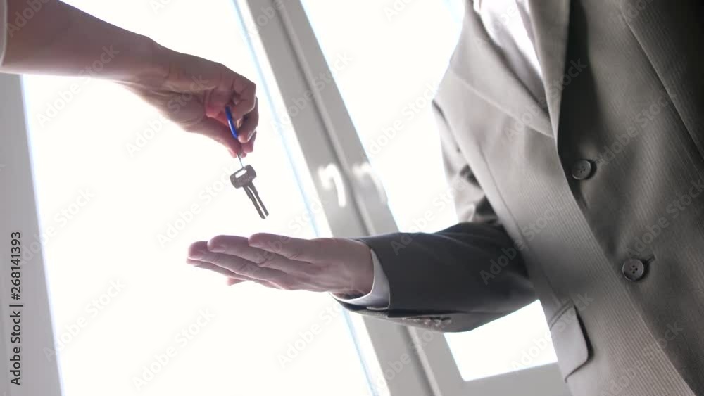 Real estate agent handing over a key to a customer on the window