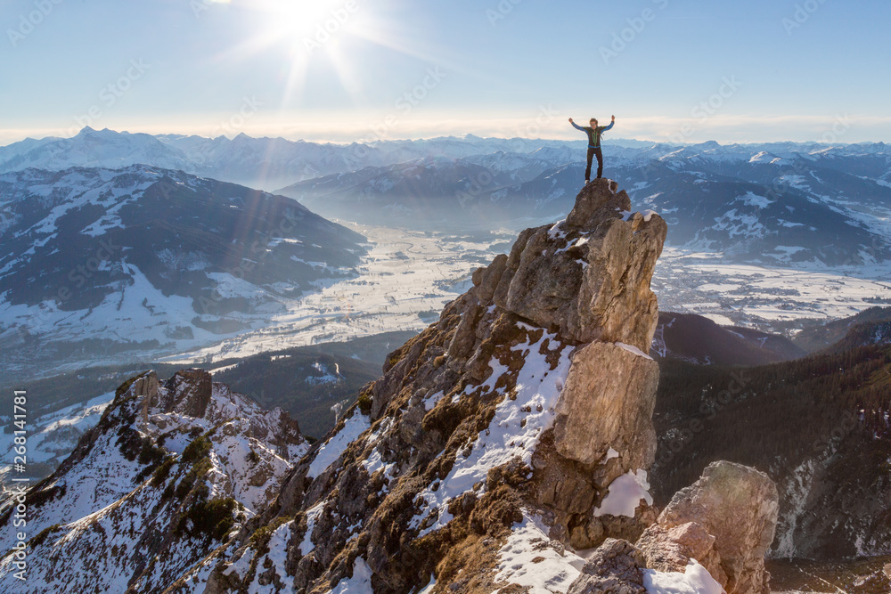 Man standing on top of a rock on a mountain