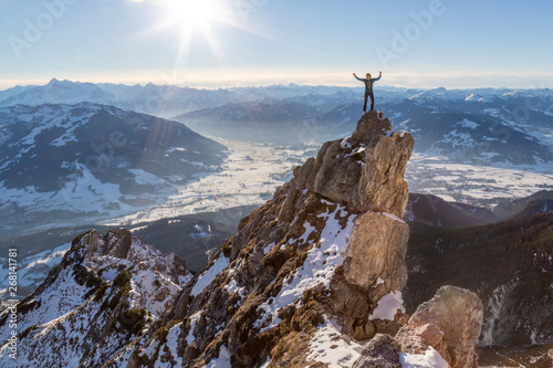 Obraz na płótnie Man standing on top of a rock on a mountain w salonie