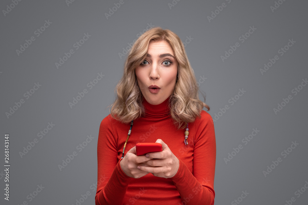 Astonished woman using smartphone Astonished woman using smartphone
