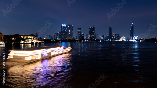Dinner yacht on chao phraya river with beautiful night city building background. Night city travel concept.
