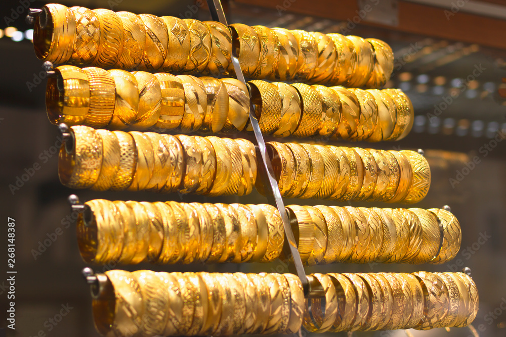 gold bracelets lined up in a jewelry store