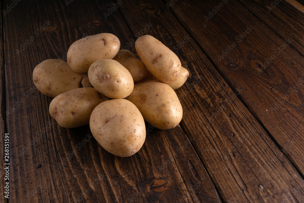 Heap of fresh clean potatoes on rustic wooden surface. Organic food, carbs, tubers. Heap of fresh clean potatoes on rustic wooden surface. Organic food, carbs, tubers.