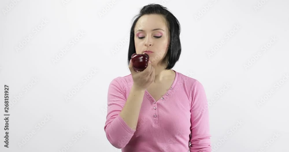 Young woman eating apple and says yum. Girl takes first bite and say wanna bite Young woman eating apple and says yum. Girl takes first bite and say wanna bite