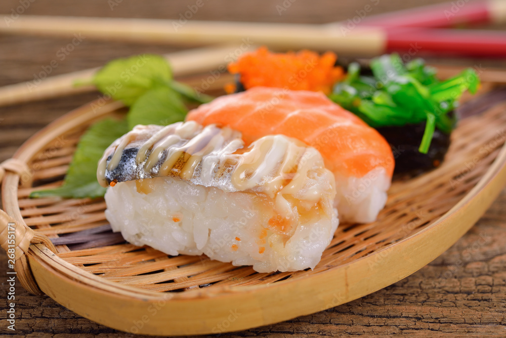 Sushi Set nigiri and sashimi served in bamboo plate on wooden background Sushi Set nigiri and sashimi served in bamboo plate on wooden background