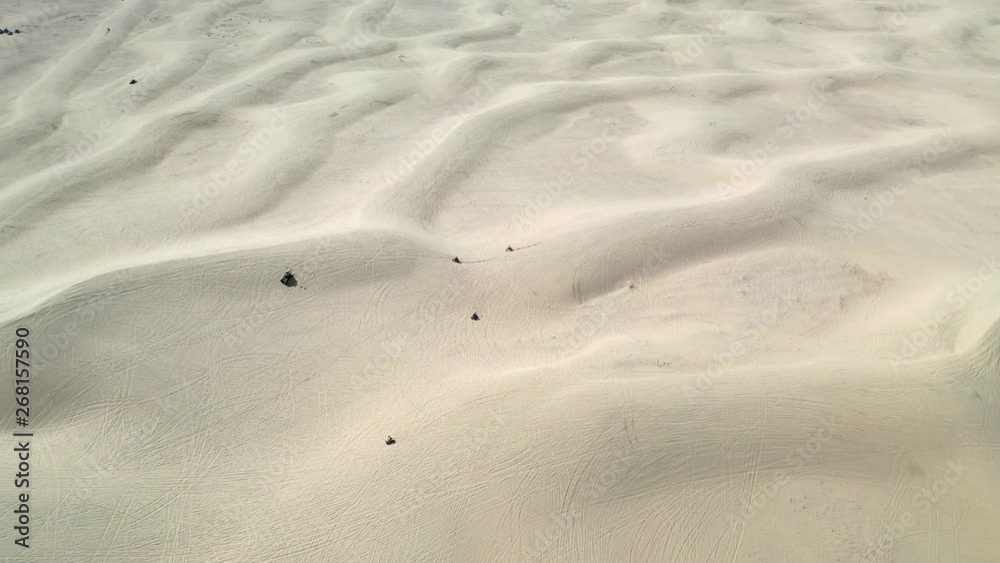Aerial, drone shot around a dune buggy, atv:s and motorcycles, driving on large dunes, on sunny day, in Sand Mountain Recreation Area, in Nevada, USA Aerial, drone shot around a dune buggy, atv:s and motorcycles, driving on large dunes, on sunny day, in Sand Mountain Recreation Area, in Nevada, USA