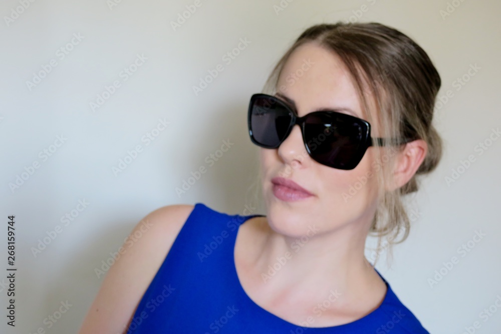beautiful girl in black sunglasses on a light background beautiful girl in black sunglasses on a light background