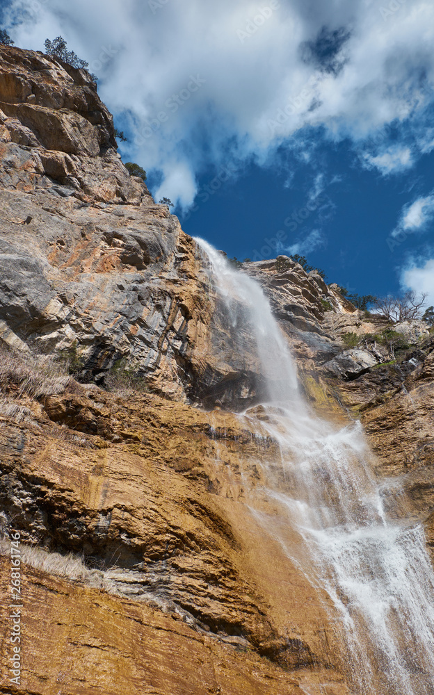 Fototapeta premium Beautiful waterfall with cloudy sky landscape. Uchan su waterfall in Yalta, Crimea, Russia.